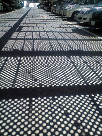夏の陽射しが駐車場にフューチャリスティックな模様を描いていた。