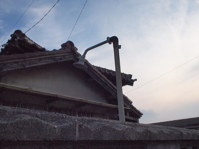 使われなくなって久しい屋外シャワーが、首をうなだれて廃屋の庭先に立っていた。