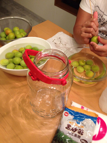 水に漬けた梅のヘタを取る作業中。