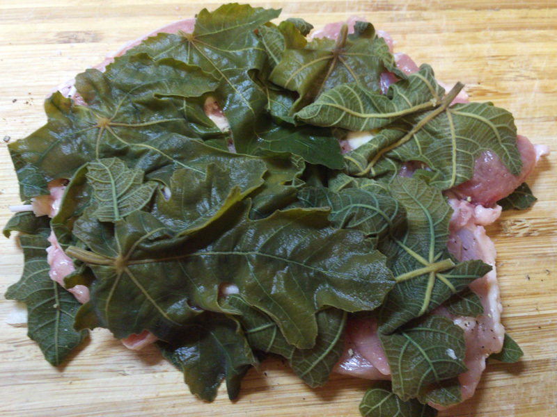 鶏もも肉をいちじくの若葉ではさみます。