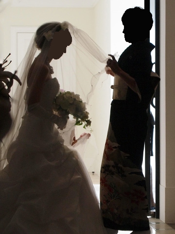 新婦の母からベールをかけられる新婦。
