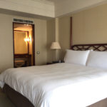 ベッド。シンプルだが、木彫りのヘッドボードと高いポールが中華風。