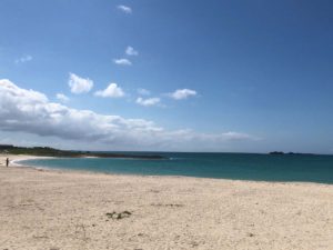 美らSUNビーチ。右手向こうにちらっと見えるのは岡波島（ウカハジマ）。