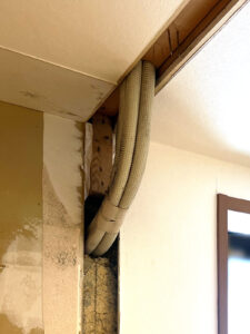 エアコンの配管が天井から壁内を経て外に繋がっていた。
