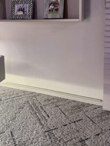 ボードの右隅下部にある壁の電源から巾木上を通らせてブラインドの裏へ誘導。