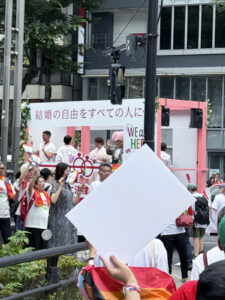 フロート。カップル3組と、ドラァグクイーンのベビーヴァギーさんが乗っている。