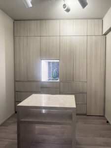 真ん中のベーステーブルは旧居からの持ち越し品。着替えで一時的に物を置く等に便利。収納に設けた飾り棚はガラストップで、テープライトを仕込んである。