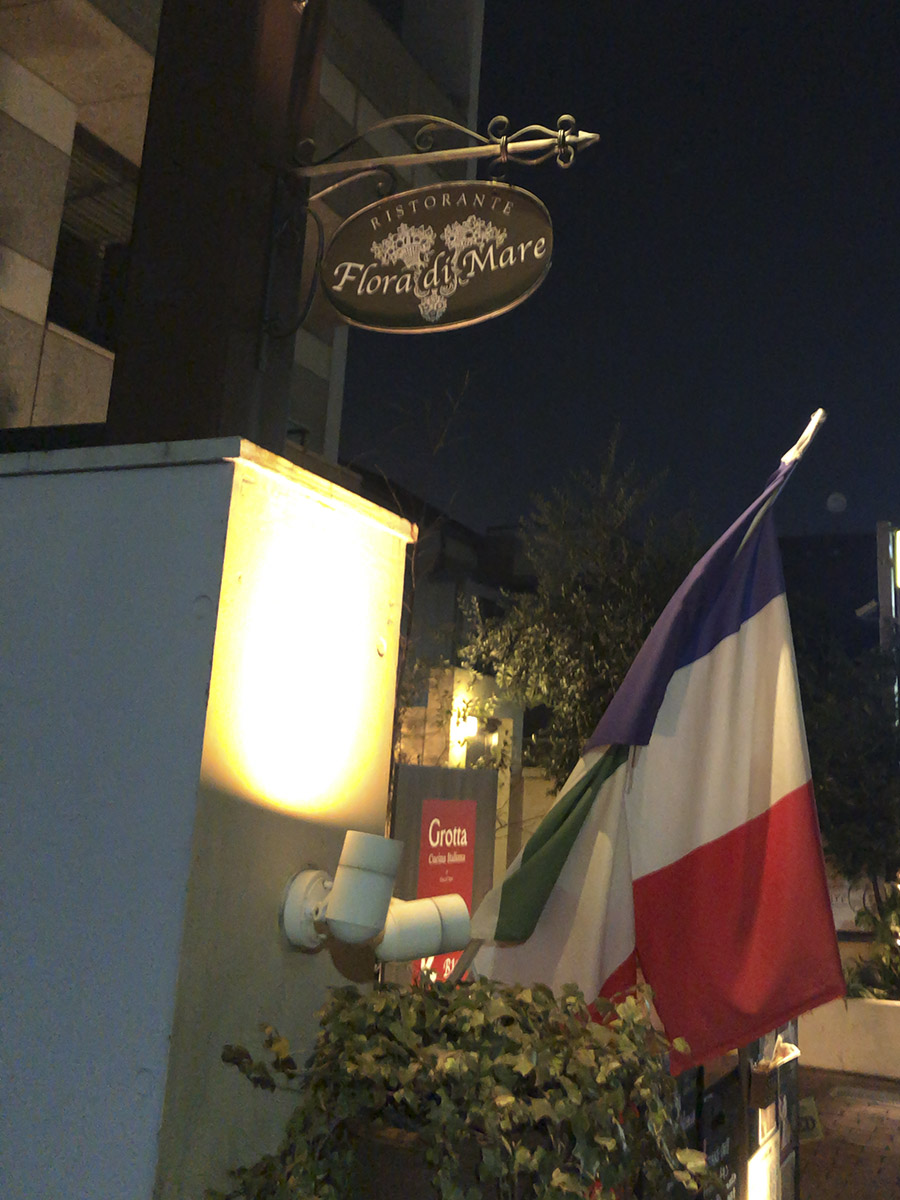アプローチ。イタリア語の店名にフランス国旗で戸惑うが、フランス国旗を信用していい。